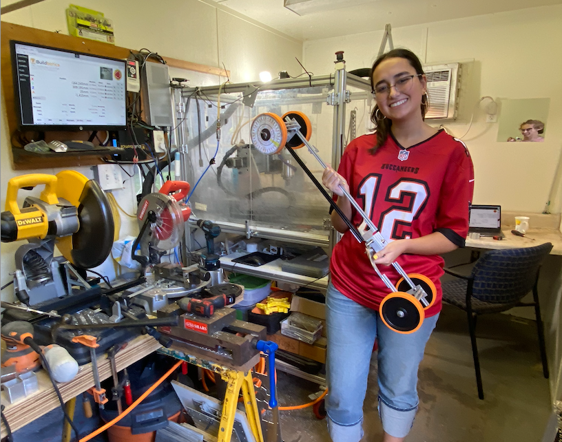 A picture of me, Eleni, next to makerspace machines.