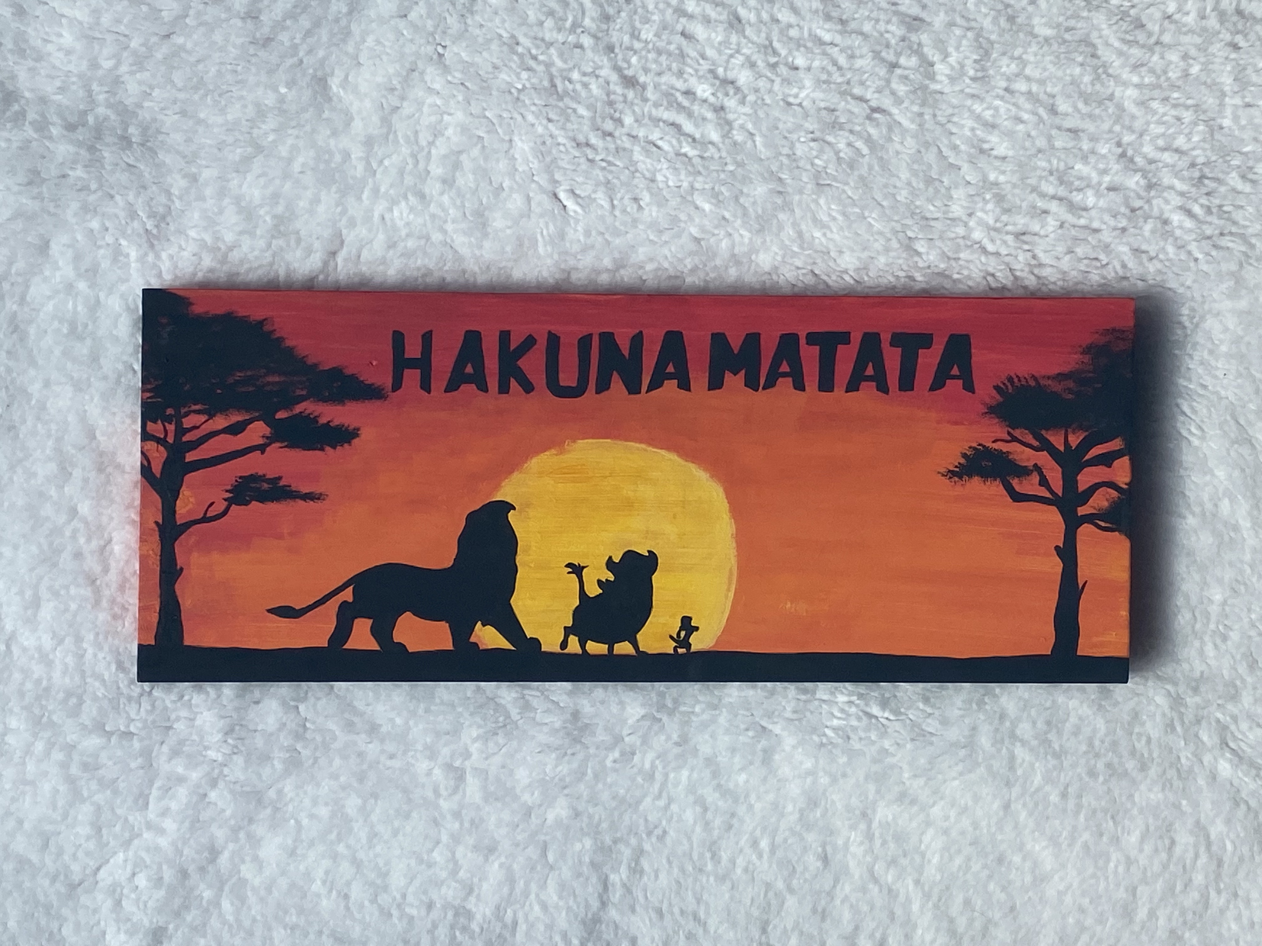A silhouette of Mufasa, Pumba, and Timon enjoying each others company during a sunrise.