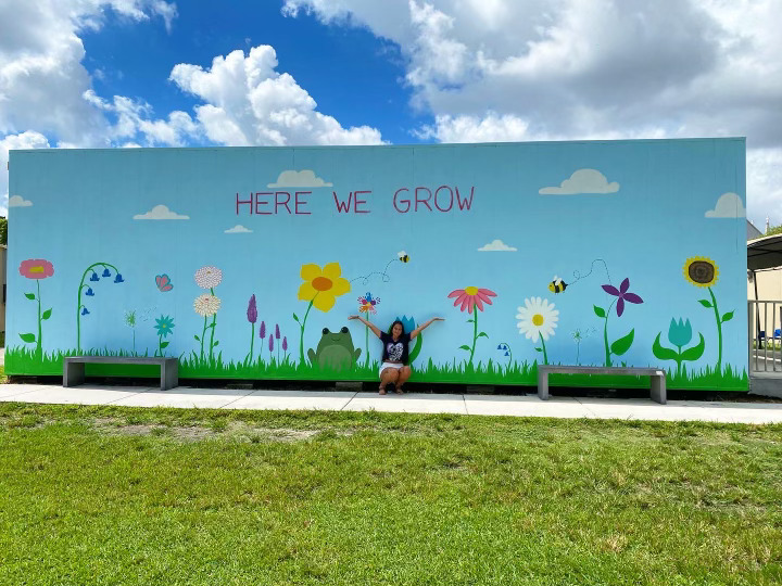 A garden mural with flowers and inspirational saying.