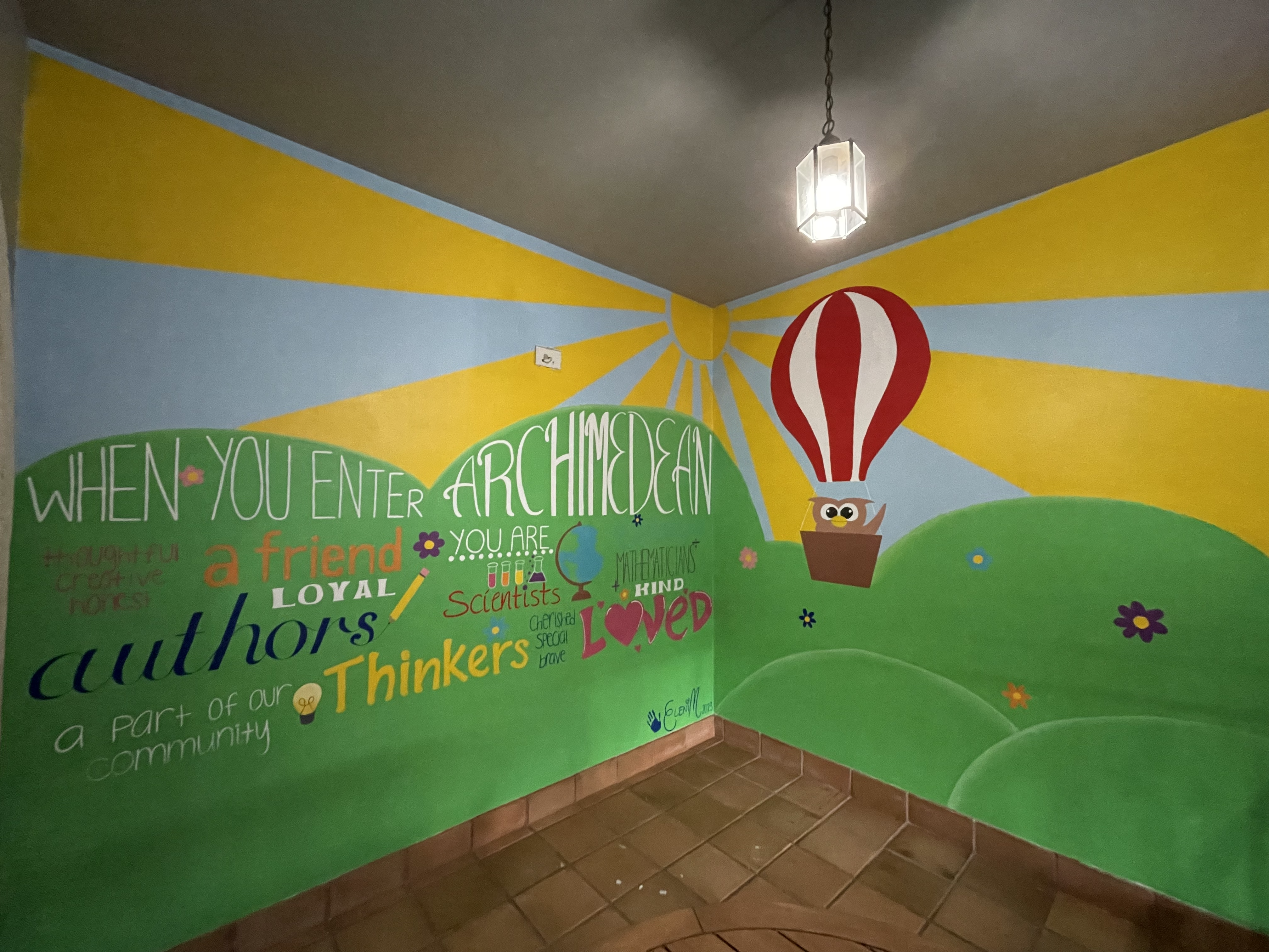 A mural of a rising sun with inspirational words.